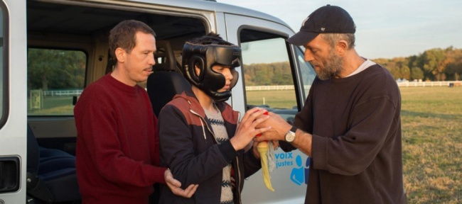 Fotograma de la película Especiales. Escena en que los cuidadores convencen a un chico con autismo para salir de la furgoneta. 
