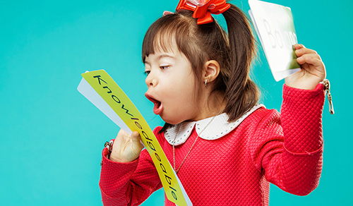 Imagen de una niña que aprende a leer una tarjeta con la palabra completa