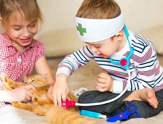 Una niña y un niño con síndrome de Down juegan a médicos. Un ejemplo de juego simbólico