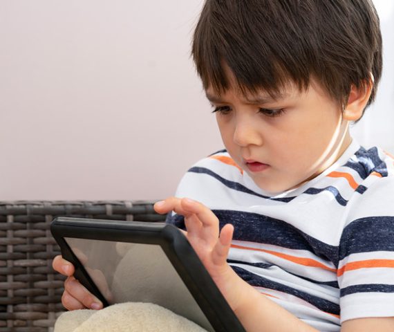 Apps para autismo. Niño con autismo juega con la tablet.