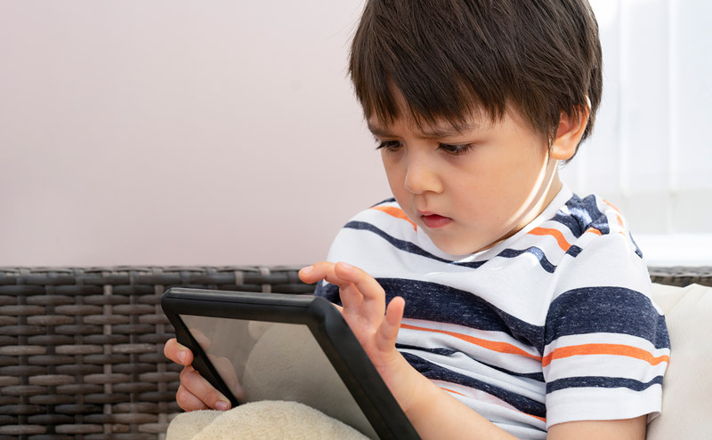 Apps para autismo. Niño con autismo juega con la tablet.